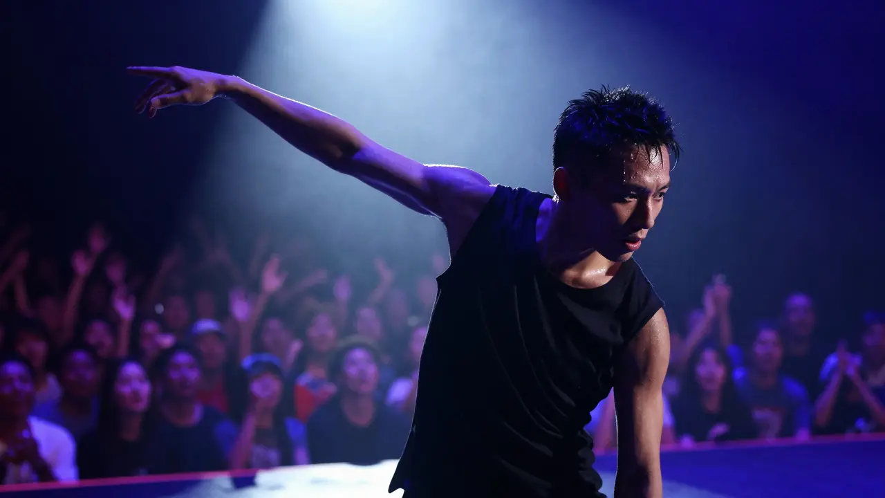 Performer executing a moonwalk on stage under a bright spotlight, audience blurred behind.